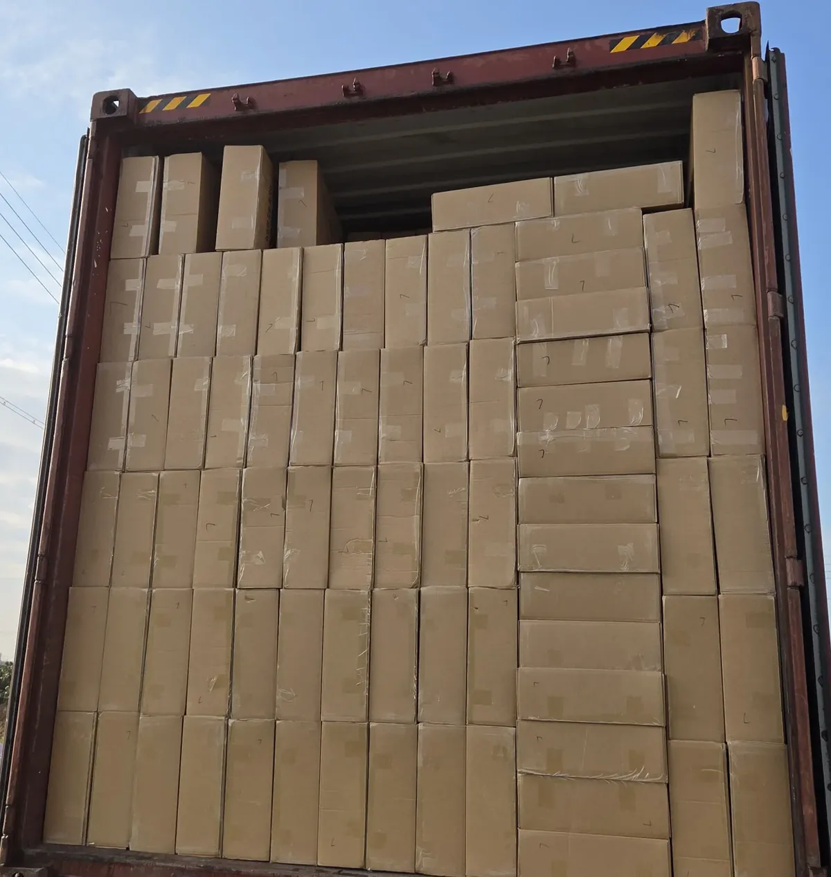 A shipping container loaded to the top with sealed cartons at the end of a run
